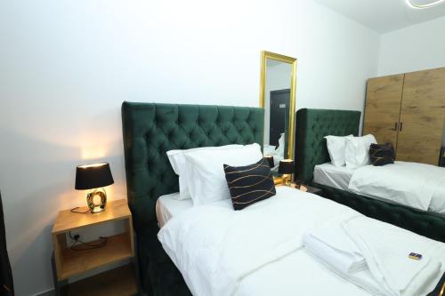 a bedroom with two beds and a green headboard at Golden Hill Palace in Novi Pazar