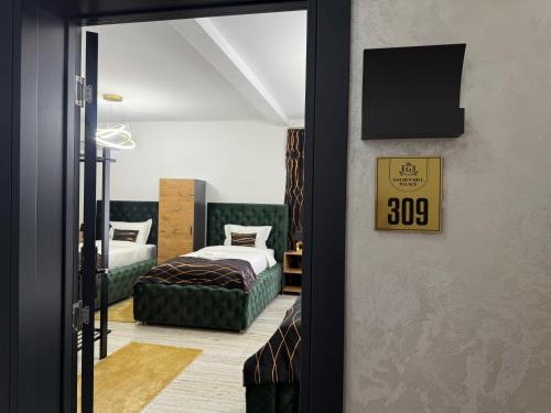 a bedroom with two beds and a sign on the wall at Golden Hill Palace in Novi Pazar