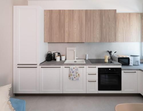a kitchen with white cabinets and a sink and a stove at Ca' Cesarino in Chioggia