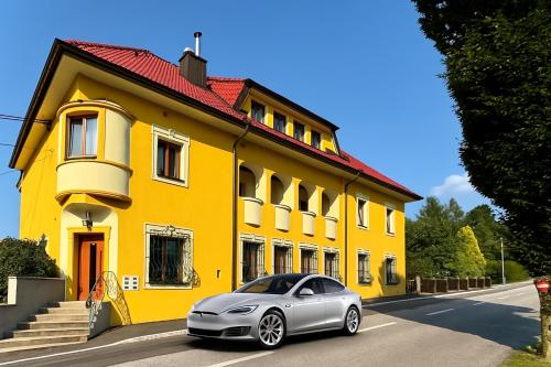 a silver car parked in front of a yellow house at Landgasthof zur Linde Laaben in Laaben