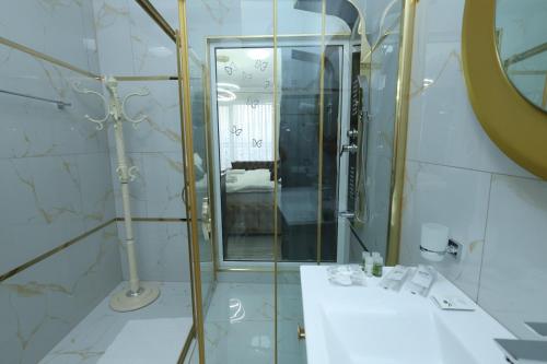 a bathroom with a shower and a sink and a mirror at Golden Hill Palace in Novi Pazar