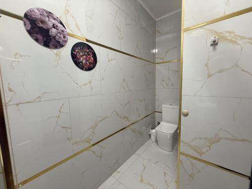 a bathroom with marble walls and a toilet at Golden Hill Palace in Novi Pazar