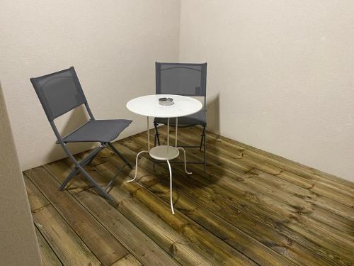 two chairs and a table in a room at Le Cocoon Evasion Spa Jacuzzi in Annoeullin