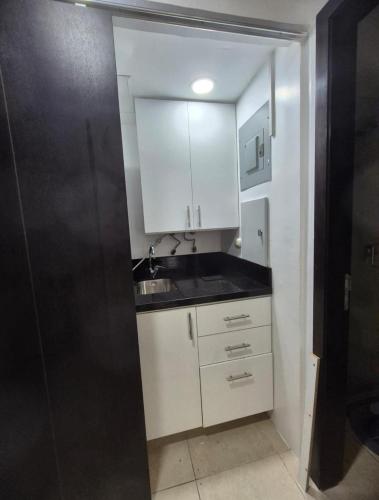 a small kitchen with a sink and white cabinets at Suite Luxury en Puerto Santana in Guayaquil