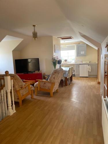 a living room with a dining table and a kitchen at Joe and Aggies in Kilclooney