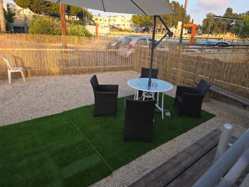 a table and chairs with an umbrella on some grass at Elias Apartment in Kissonerga