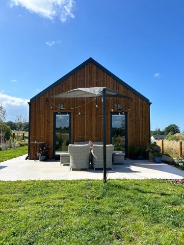 a large wooden barn with an umbrella and chairs at Makihyte dom na wyłączność z panoramą na morze i strefą SPA in Sasino