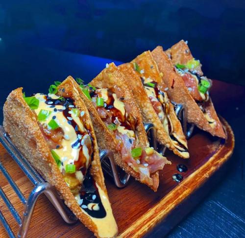 three tacos on a wooden plate with a fork at CARIBBEAN STUDIOS DELUXE with ROOFTOP POOL and SPA - LOS CORALES BEACH in Punta Cana