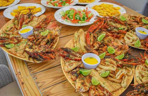 a table topped with different types of seafood and dips at CARIBBEAN STUDIOS DELUXE with ROOFTOP POOL and SPA - LOS CORALES BEACH in Punta Cana