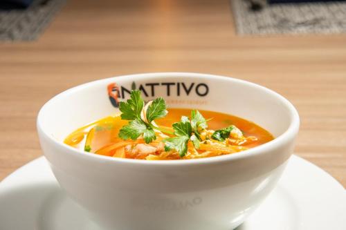 a white bowl of soup sitting on a plate at Crowne Plaza San Jose La Sabana by IHG in San José