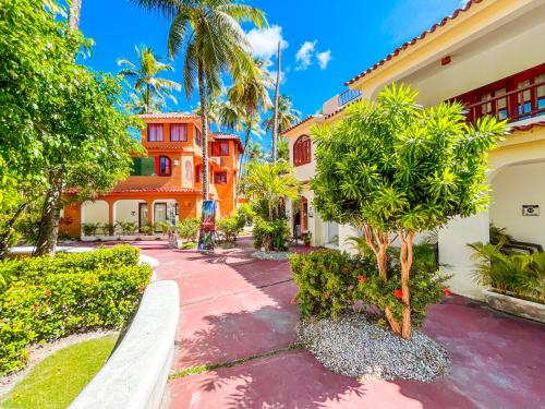 a walkway in front of a building with trees at LOS CORALES Resort VILLAS & Apartments WIFI BEACH Club & SPA in Punta Cana