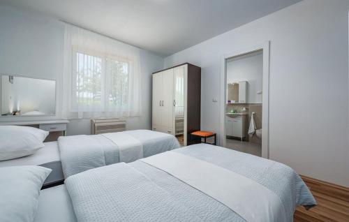 een witte slaapkamer met 2 bedden en een spiegel bij Villa Roko in Barban
