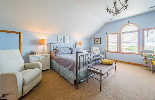 a bedroom with a bed and a couch and a chair at By the Sea in Kill Devil Hills