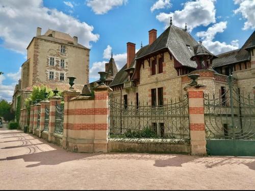 an old building with a gate and a castle at Appartment Mal coiffé in Moulins