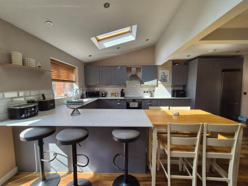 a kitchen with a large island with bar stools at Location, lovely family home in Melksham