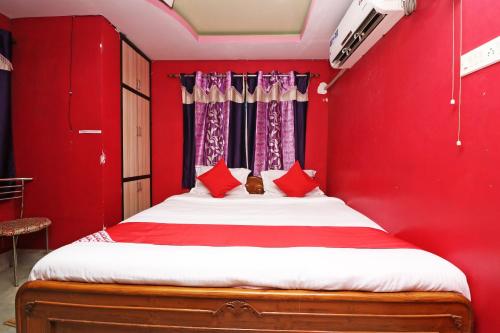 a red bedroom with a bed with red pillows at Xpress Inn in Garui