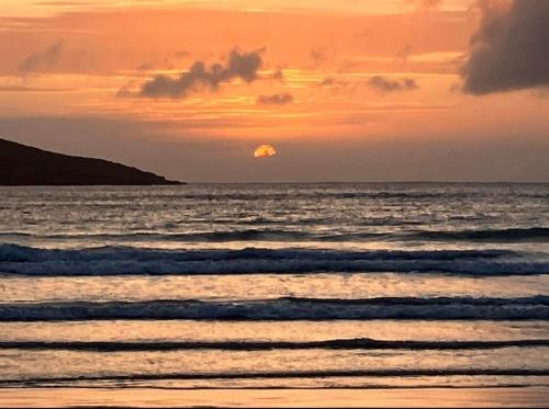 a sunset over the ocean with the sun in the distance at Joe and Aggies in Kilclooney