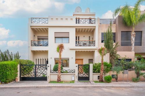 ein Haus mit Palmen davor in der Unterkunft Villa Meraki in Marrakesch