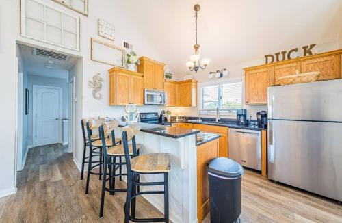 a kitchen with wooden cabinets and a stainless steel refrigerator at Sounds Great! in Duck