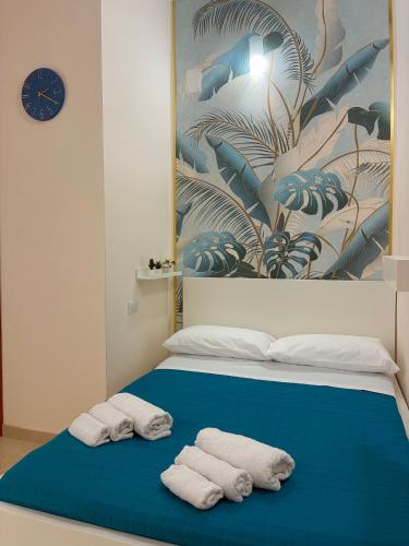 a bedroom with two towels on a blue bed at TiTò Apartment in Naples