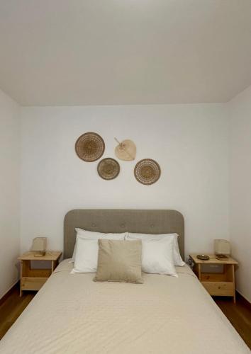 a bedroom with a bed with three plates on the wall at Casal do Pequeno in Alcobaça