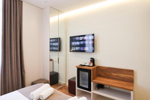 a hotel room with a bed and a television at The MONT BOUTIQUE HOTEL in Shkodër