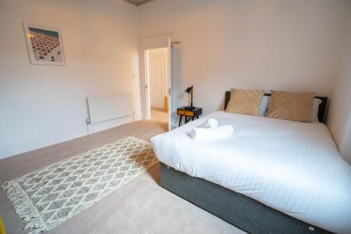 ein Schlafzimmer mit einem großen weißen Bett und einem Teppich in der Unterkunft Flat Sixteen in Redcar