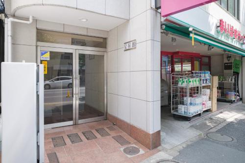 a store front with its door open on a street at Dormitory サークルテン- Share Room For Male Only 男性専用ドミトリー in Tokyo