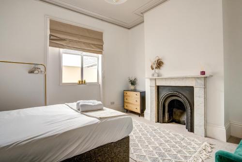 ein weißes Schlafzimmer mit einem Bett und einem Kamin in der Unterkunft Flat Sixteen in Redcar