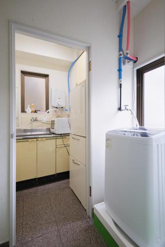 a kitchen with a sink and a refrigerator at Dormitory サークルテン- Share Room For Male Only 男性専用ドミトリー in Tokyo