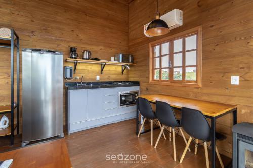 a kitchen with a dining table and a refrigerator at Cabana romântica com vista na serra VST033 in São Paulo dos Pinhais