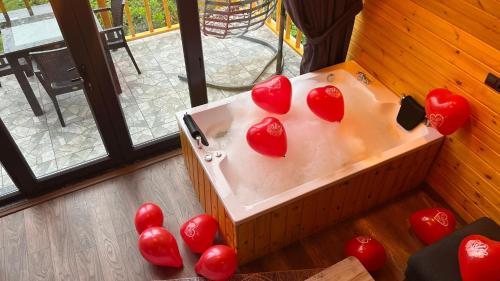 a bath tub with red hearts on top of it at AĞARAN DAĞ EVLERi in Cayeli