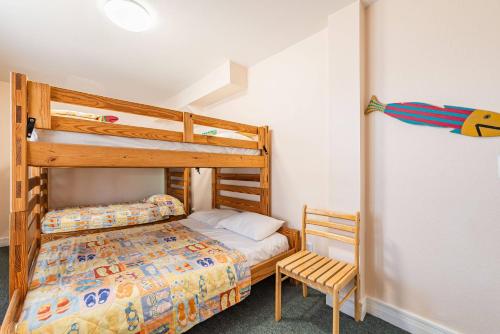 - une chambre avec 2 lits superposés et une chaise dans l'établissement Carolina Sunshine, à Nags Head