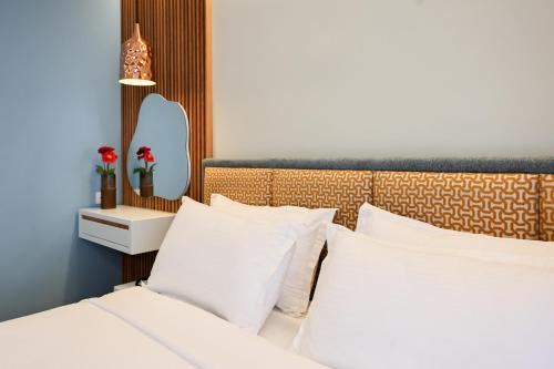 a bedroom with a bed with white pillows and a headboard at The MONT BOUTIQUE HOTEL in Shkodër