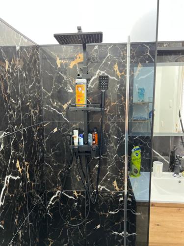 a bathroom with a black marble wall at Cosy rental - Normandy in Sourdeval