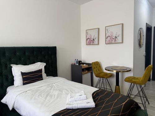 a bedroom with a bed and two chairs and a table at Golden Hill Palace in Novi Pazar