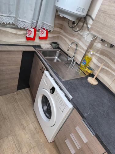 a washing machine in a kitchen next to a sink at Vivenda da Tendeirinha in Arrentela