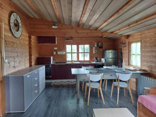 a kitchen with a table and chairs in a cabin at Pause nature au cœur des forêts in Saint-Pal-de-Senouire