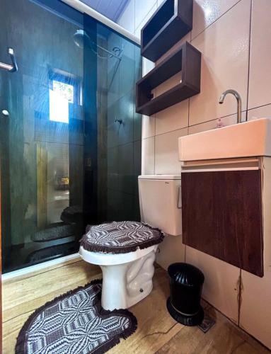 a bathroom with a shower and a toilet and a sink at Chalé do Lago 1137 in Itu