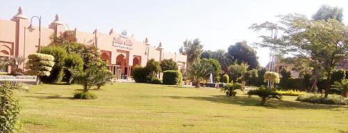 a large yard with a building and trees in front of it at Jolie Ville Hotel & Spa Kings Island Luxor in Luxor