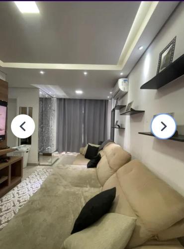 a living room with a couch and a tv at Apartamento no centro de Hortolândia e a 5 minutos de Sumaré in Hortolândia