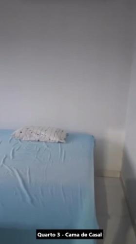 a bed in a room with a white wall at Casa Alcobaça in Alcobaça