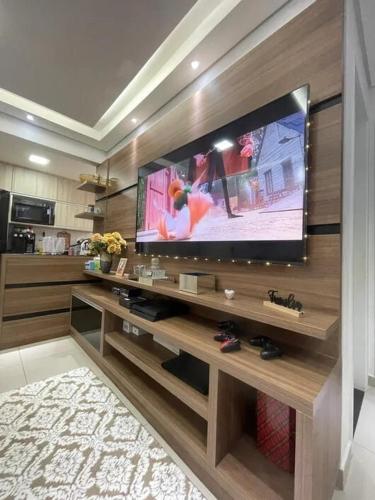a living room with a large flat screen tv at Apartamento no centro de Hortolândia e a 5 minutos de Sumaré in Hortolândia