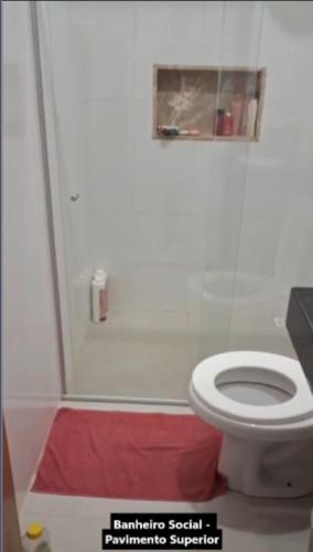 a bathroom with a white toilet and a red rug at Casa Alcobaça in Alcobaça