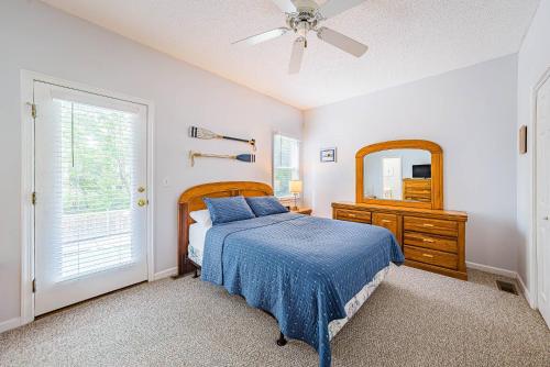 a bedroom with a bed and a dresser and a mirror at Currituck Carl's in Sanderling