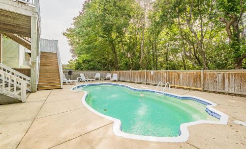 a swimming pool on a patio with a wooden fence at Currituck Carl's in Sanderling