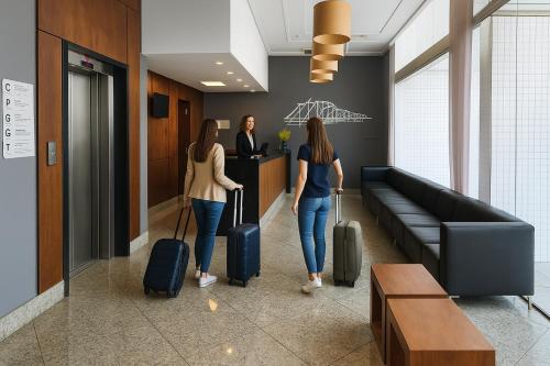 two women walking down a hallway with luggage at Flat Praia do Canto 2Q-2B Long Stay TRIÂNGULO DAS BERMUDAS in Vitória