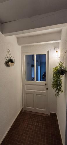 a white door with a window and a plant at Chambre Étape Isabielle in Saint-Vaury