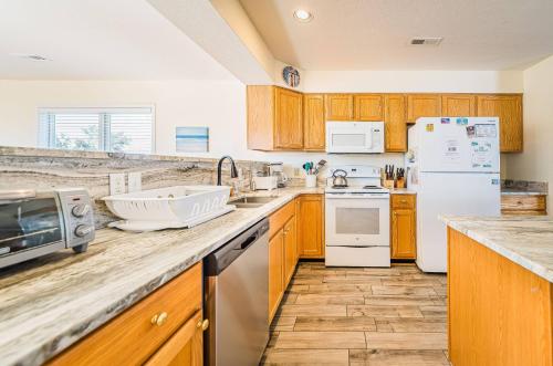a kitchen with wooden cabinets and white appliances at Follow the Sun in Duck