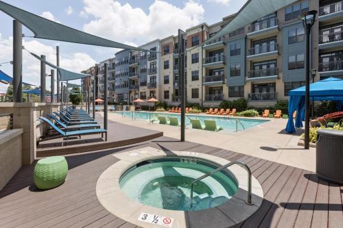 a swimming pool with a hot tub in front of a building at 2 Bedroom Boutique Apartment in the Heart of Charlotte in Charlotte
